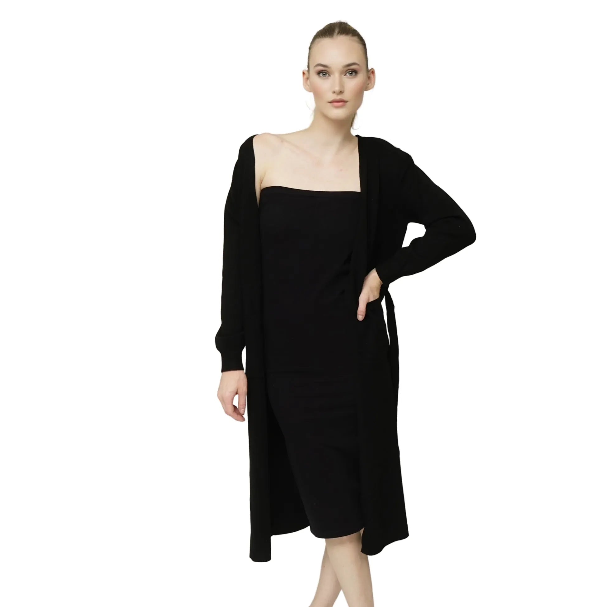 Woman wearing a black dress with a matching long duster on a plain background
