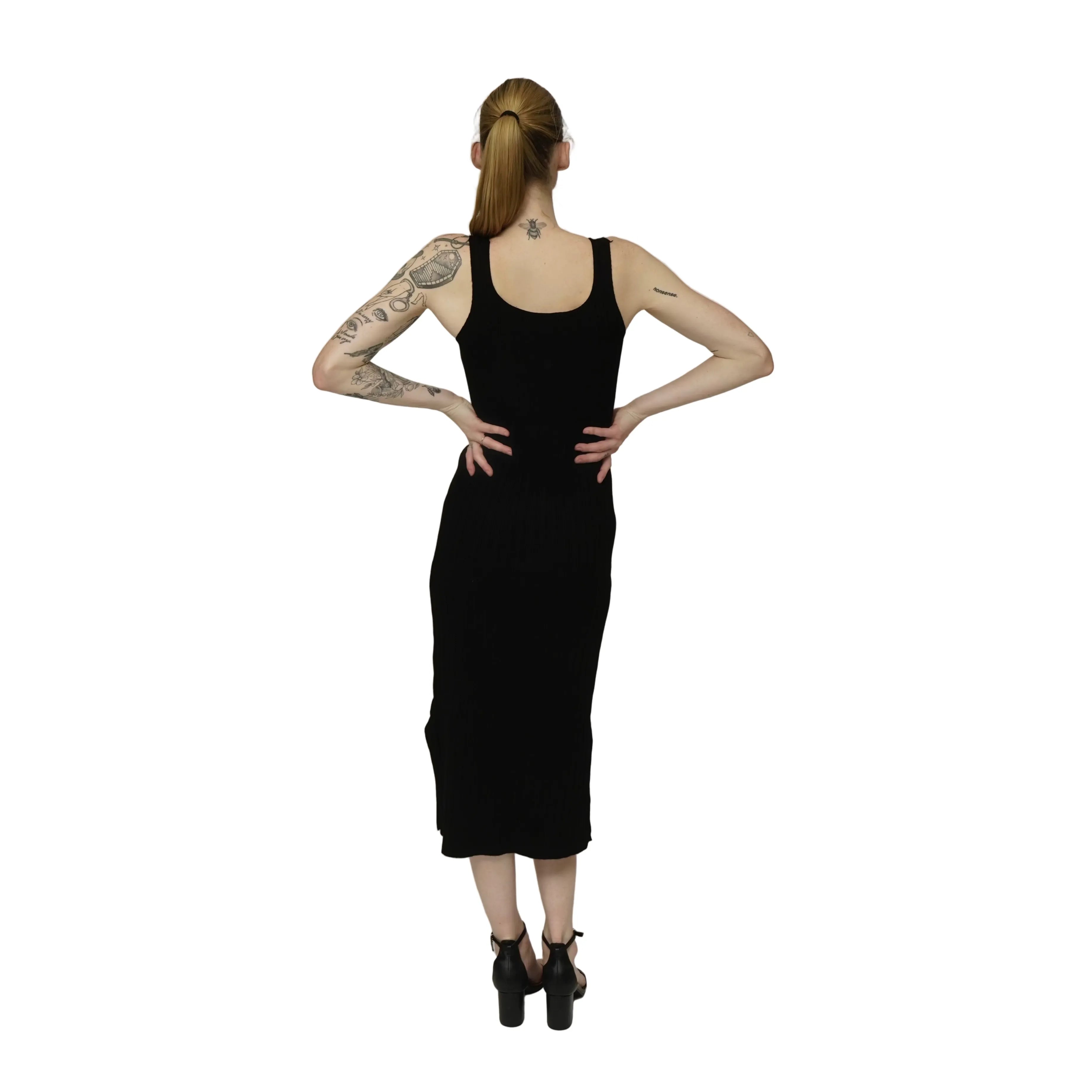Person wearing a black sleeveless dress against a plain background