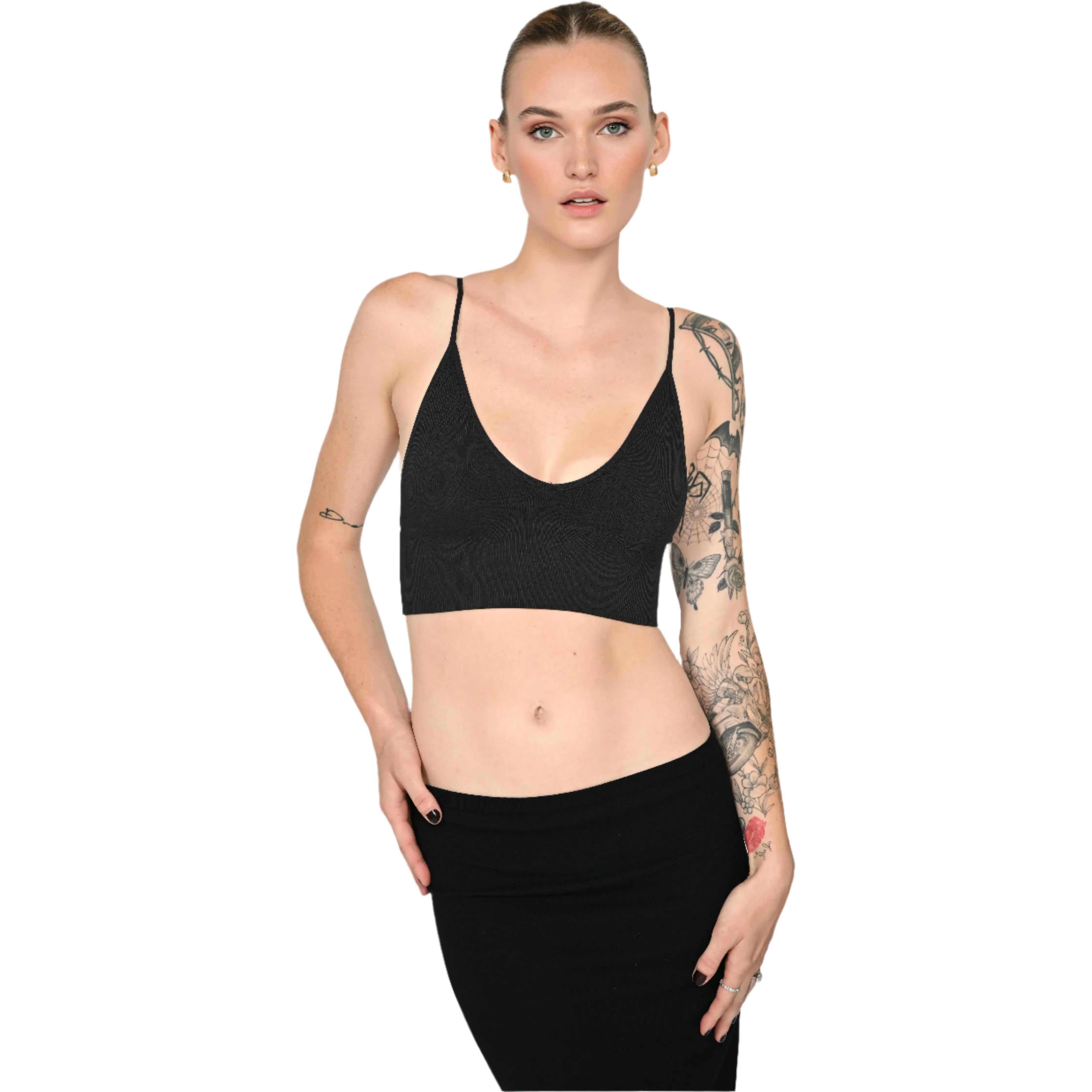Woman wearing a black bralette and black skirt against a white background