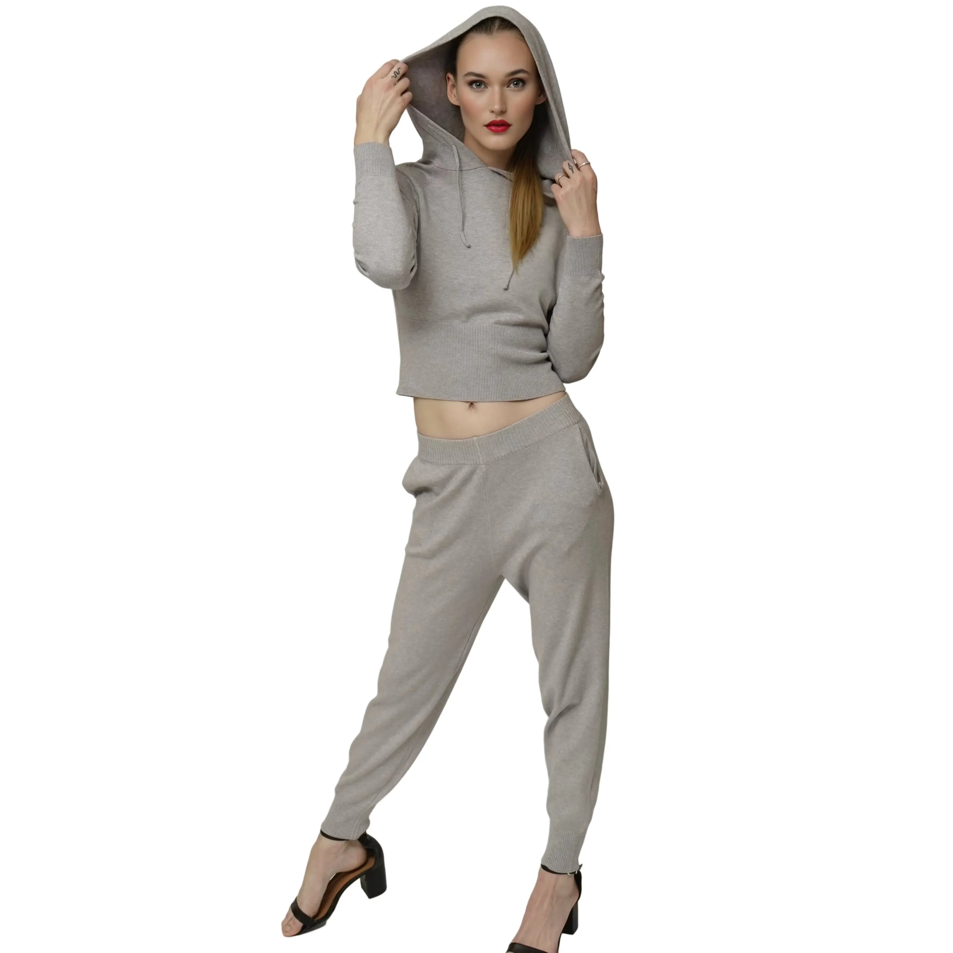 Woman wearing a gray hoodie and pants on a plain background