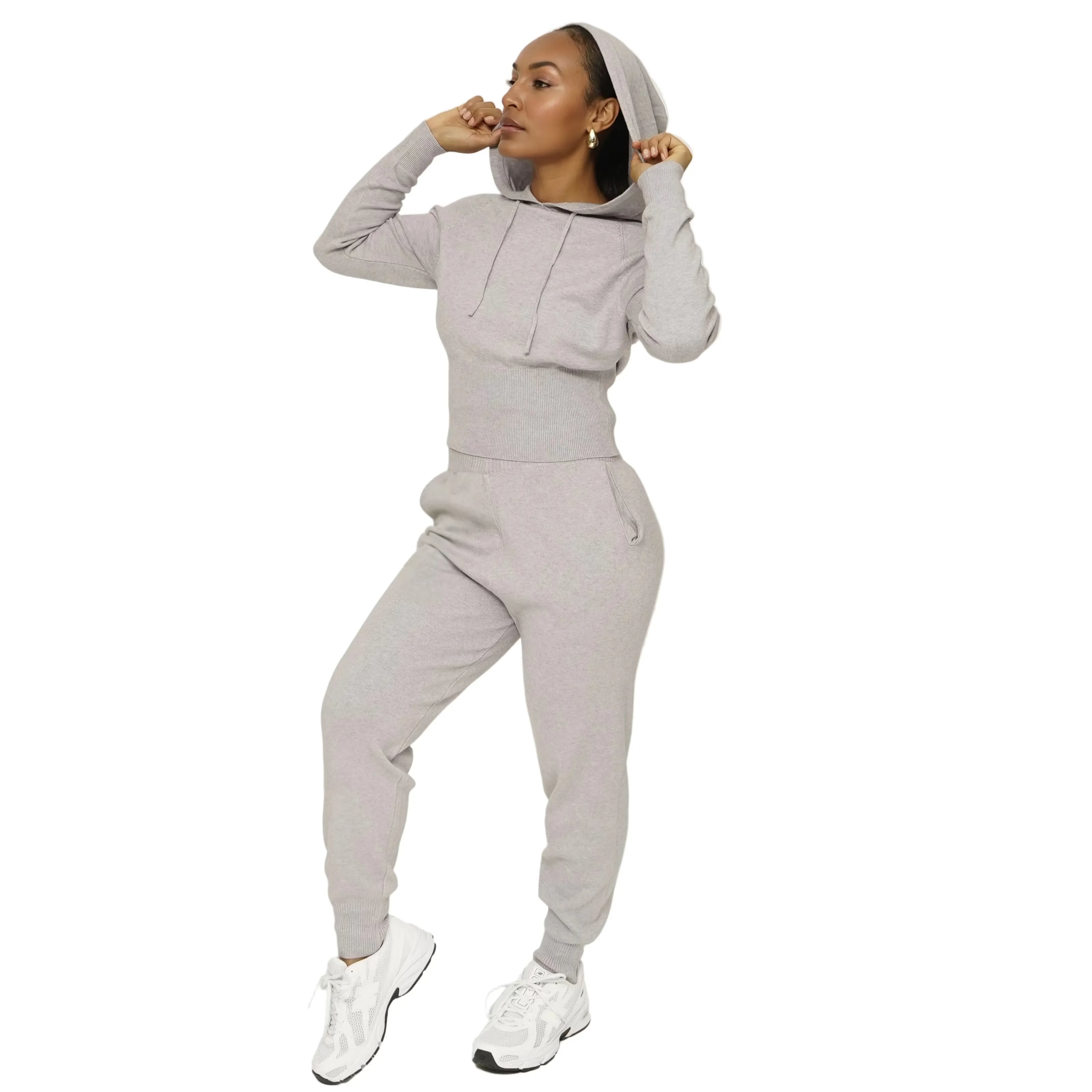 Person wearing a gray hoodie and matching pants on a white background