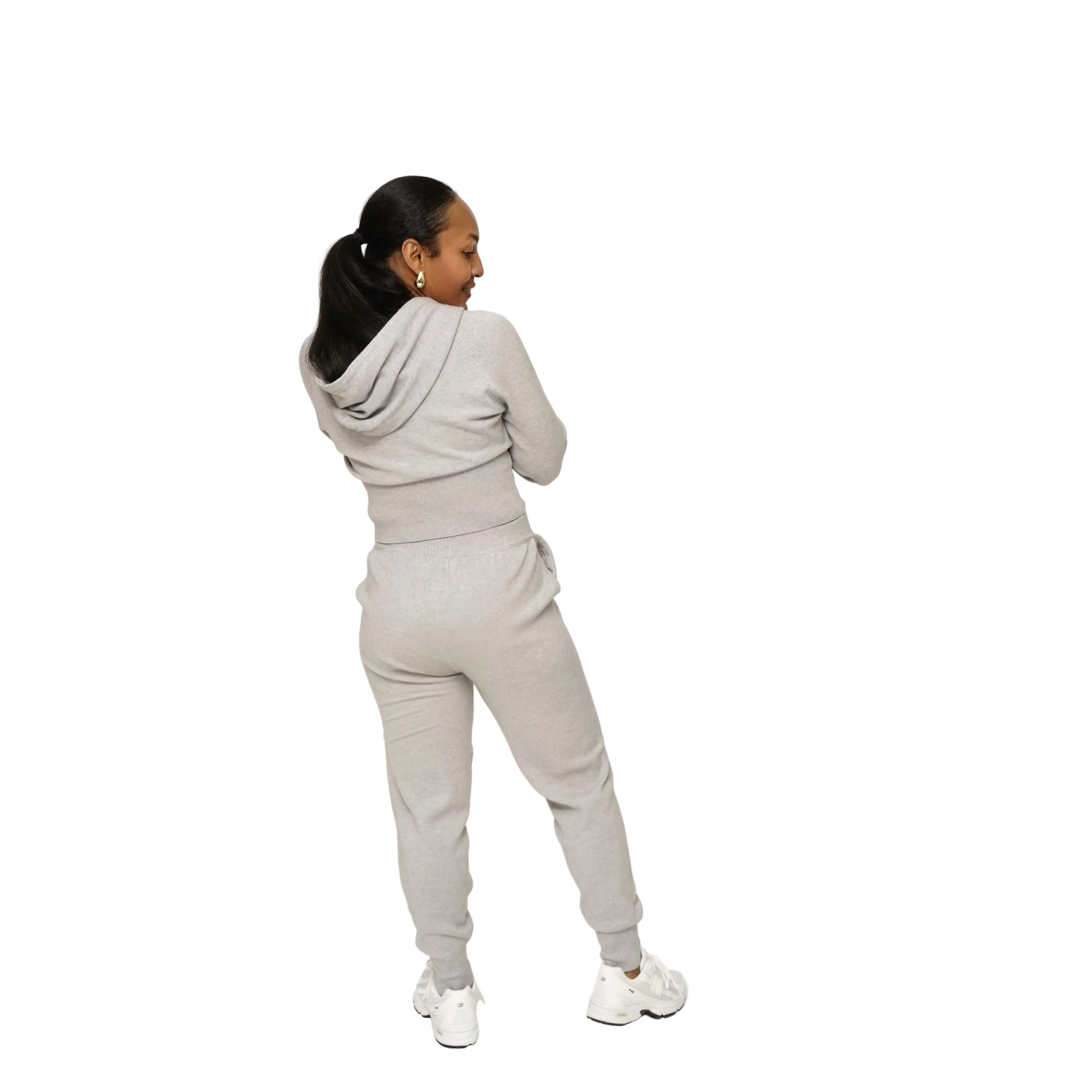 Person wearing a gray tracksuit on a white background